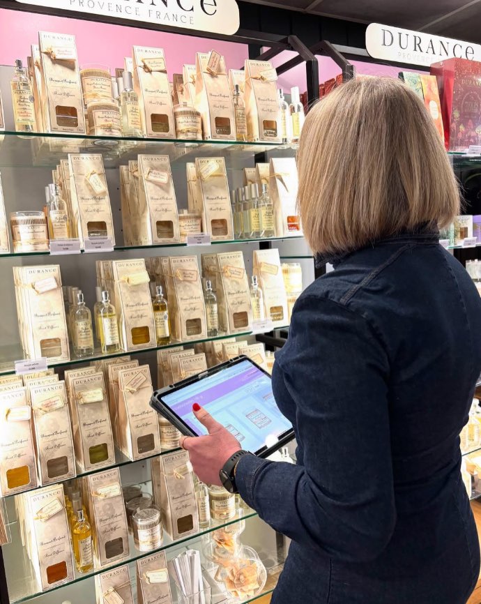 Claire en boutique devant le rayon de bougies et diffuseurs parfumés